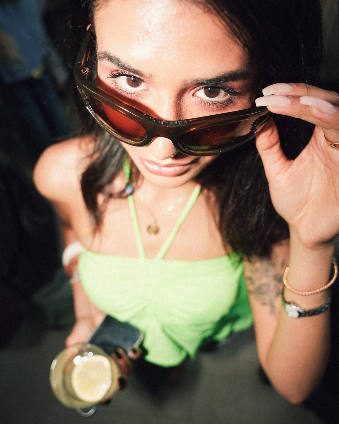 Guest lowering her sunglasses at the camera, Seraya AW1 party — photo by vinny.mp4, Stockholm