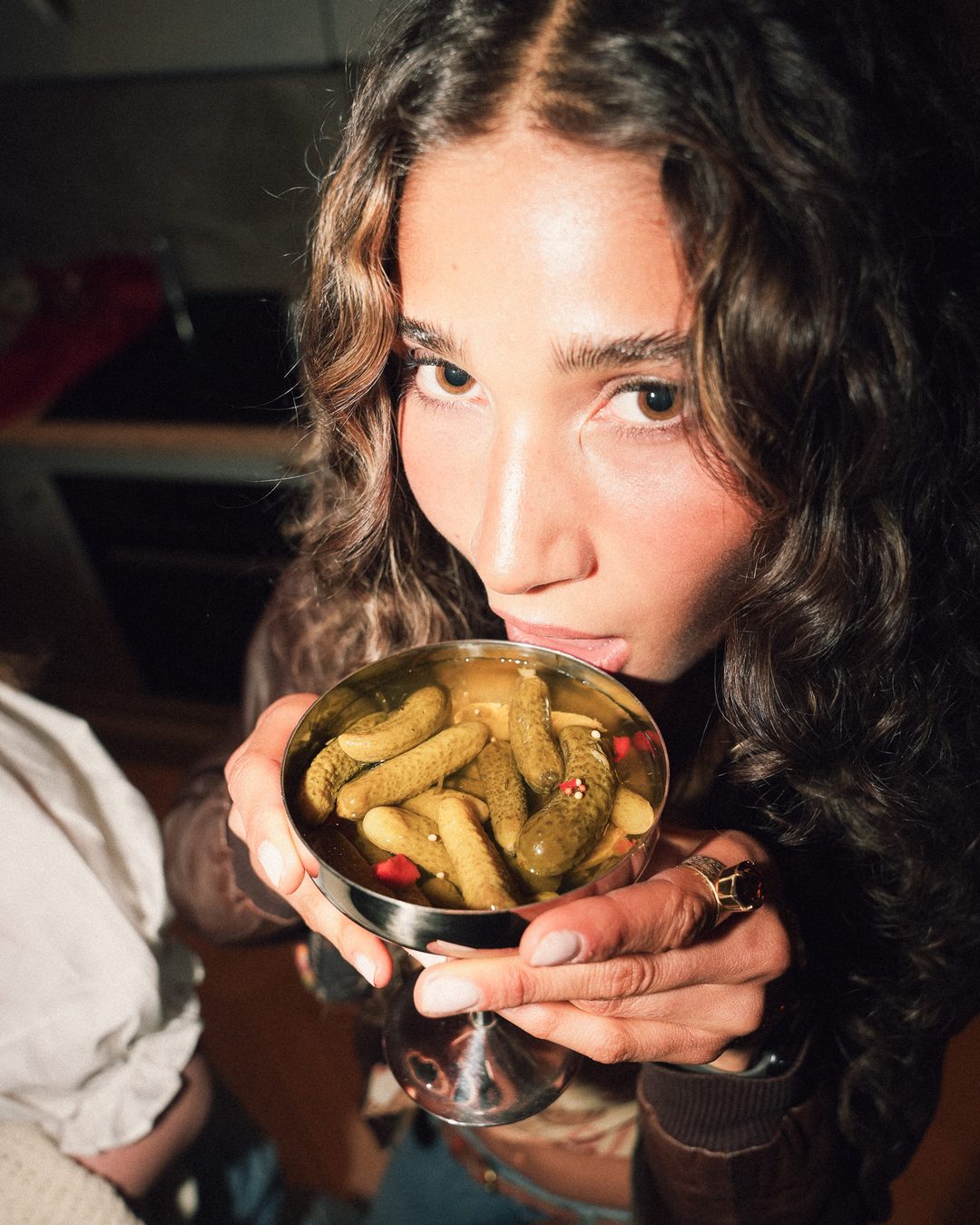 Guest holding up a glass bowl of pickles, Seraya AW1 party — photo by vinny.mp4, Stockholm